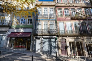 A row of multi-story buildings with various storefronts, including a jewelry store and a specialty coffee shop. - Casa do Ofício - Bookseller 1 by Hosty (Porto)