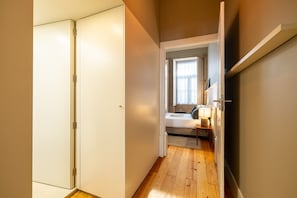 A narrow hallway with a bed and a nightstand in a bedroom. - Casa do Ofício - Bookseller 1 by Hosty (Porto)