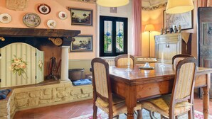 A dining area with a wooden table, chairs, and a fireplace. - Historic Villa with Florence View and Hot Tub (Lastra a Signa)