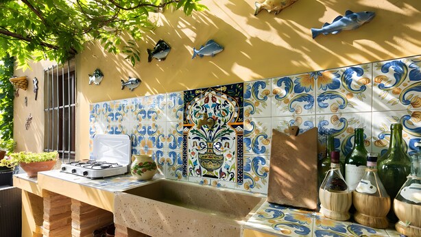 A kitchen with a tiled backsplash, a sink, a stove, and decorative fish. - Historic Villa with Florence View and Hot Tub (Lastra a Signa)