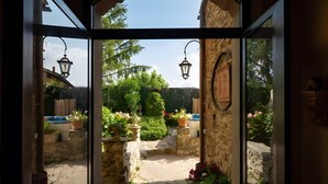 An arched doorway leading to a stone pathway surrounded by potted plants and a well-maintained garden. - Historic Villa with Florence View and Hot Tub (Lastra a Signa)