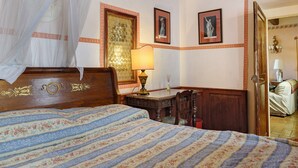 A bedroom with a bed, a nightstand, a lamp, and a door leading to another room. - Historic Villa with Florence View and Hot Tub (Lastra a Signa)