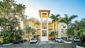 A multi-story hotel with a central atrium, balconies, and a parking area. - Stylish 3BR Penthouse Ocean Views, Sosúa Center (Sosúa)
