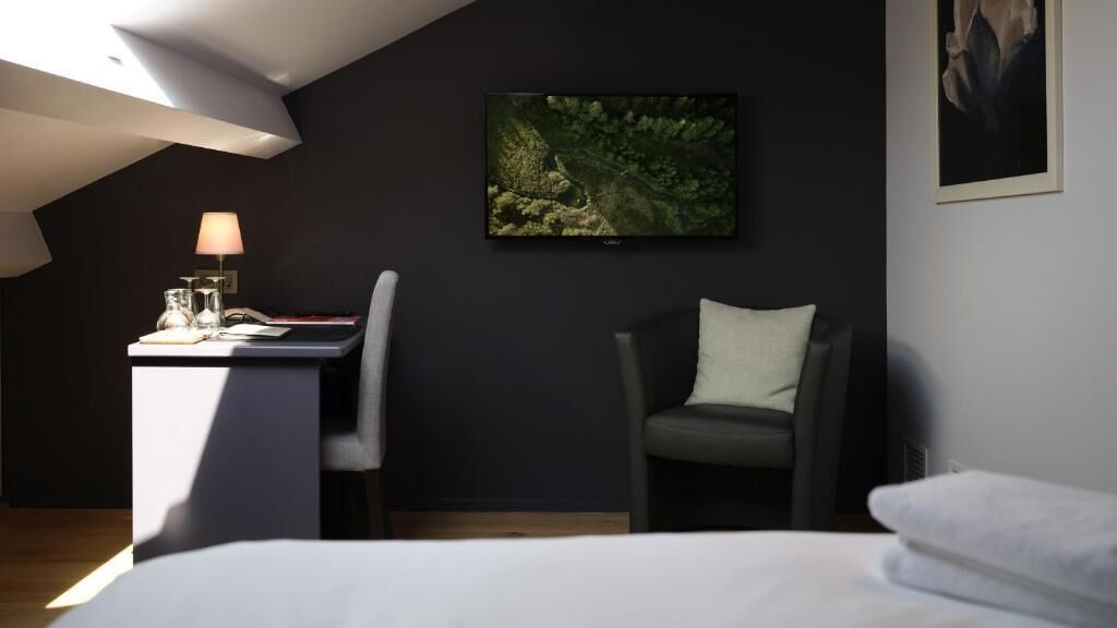 A modern room with a desk, chair, and bed.