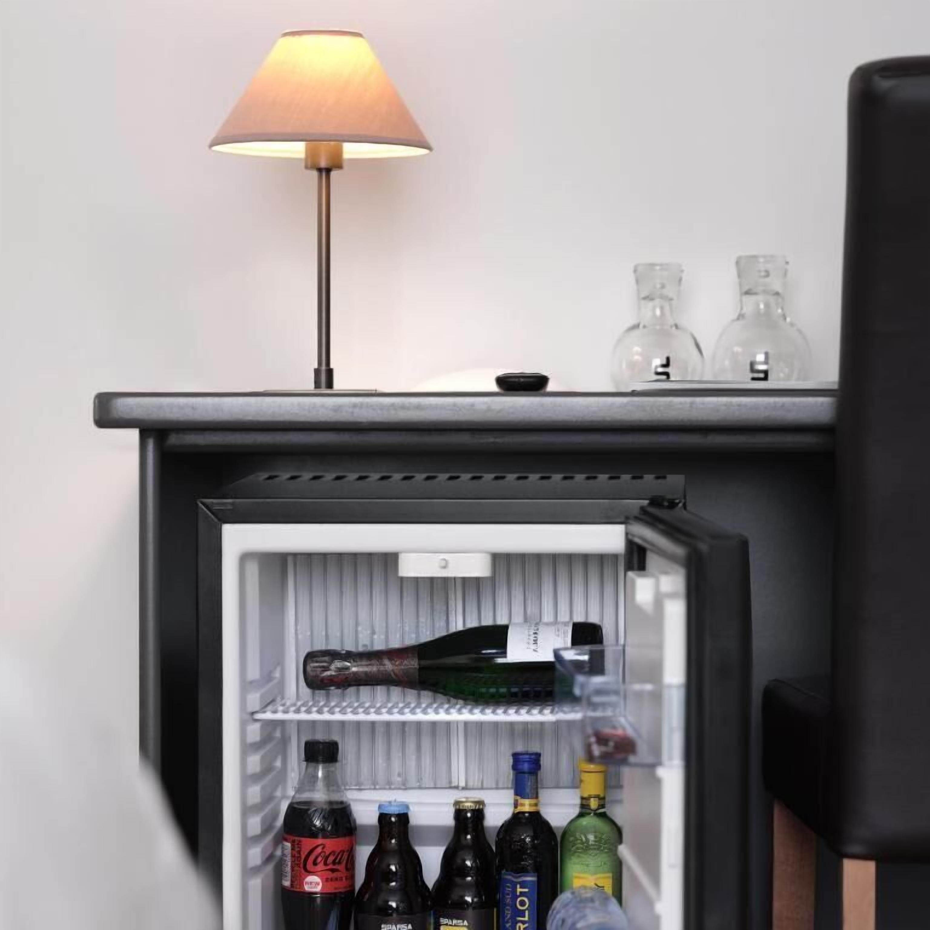 Un frigorifero con una bottiglia di Coca-Cola, diverse bottiglie di vino e due bottiglie trasparenti sullo scaffale superiore.