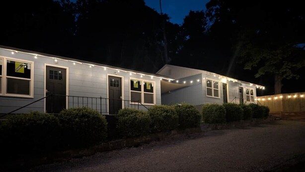 Uma casa com entrada por caminho de pedras e fachada bem iluminada.