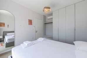 Une chambre d’hôtel moderne, équipée d’un lit, d’une armoire et d’un miroir.