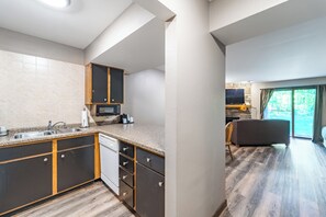 A modern kitchen with dark cabinetry, a built-in microwave, and a sink. - Cozy 1 bedroom located on Granite Peak, Unit 7 (Wausau)