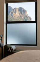 Una habitación con un ventanal grande con vistas a un paisaje montañoso.