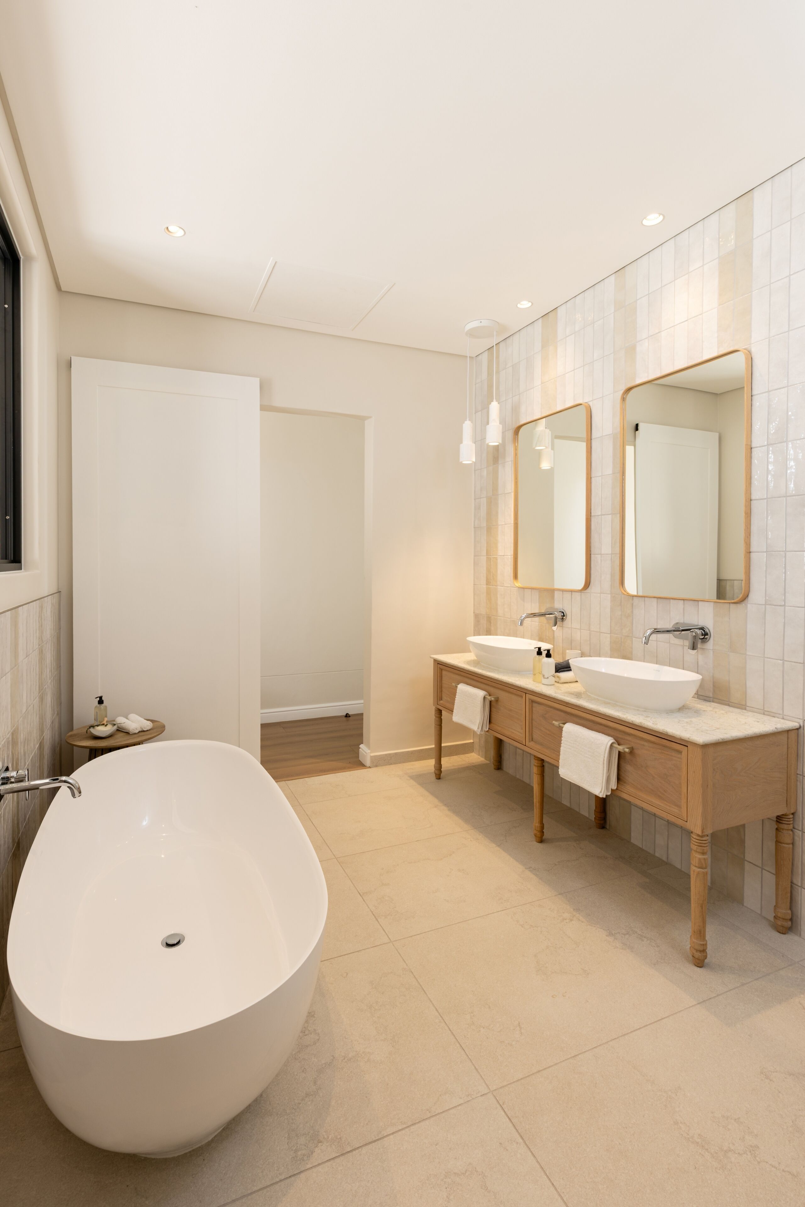 Un bagno moderno con una vasca freestanding, un lavabo doppio e uno specchio grande.