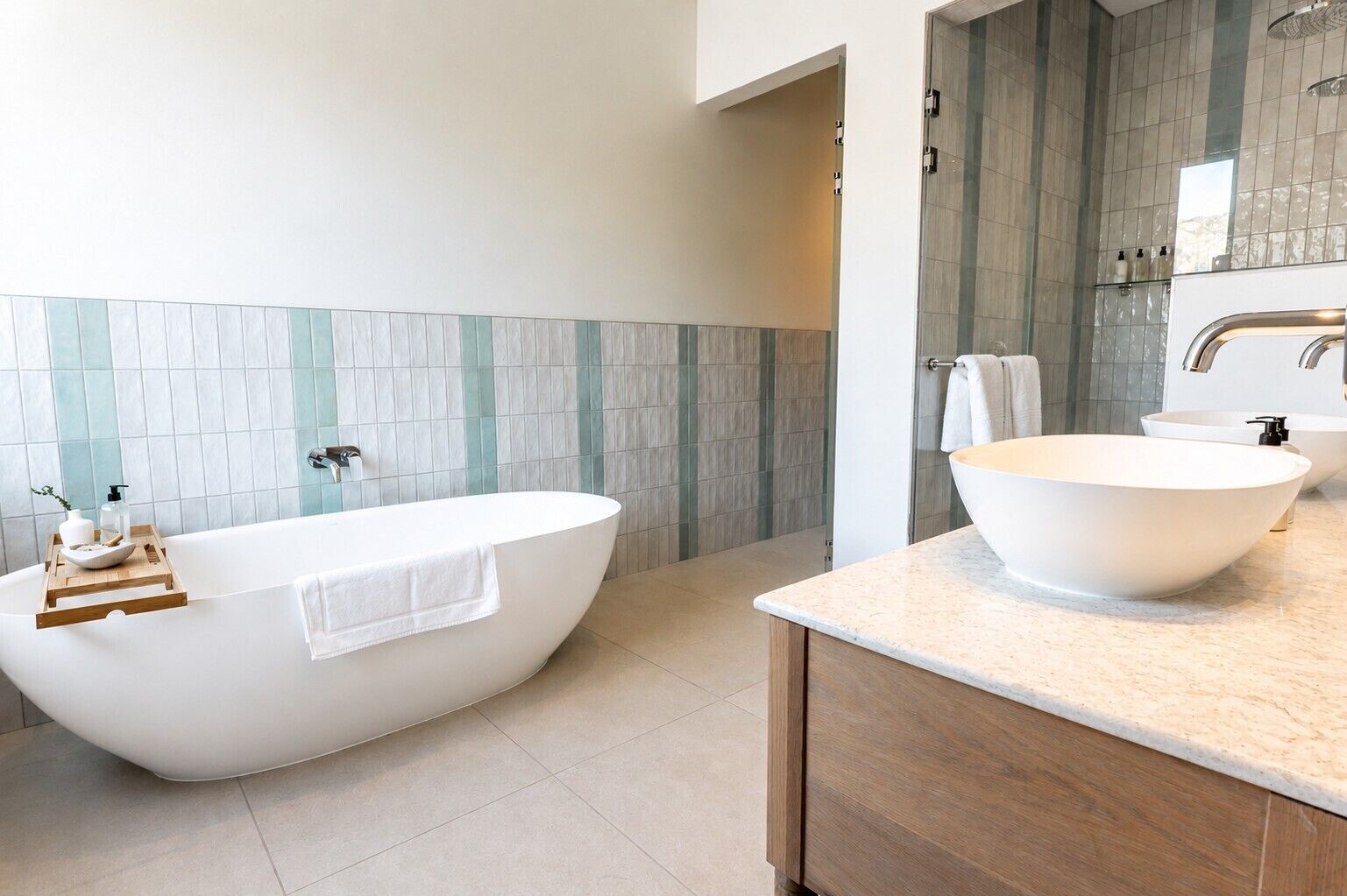 Un baño moderno con una bañera independiente, un lavamanos grande y un mueble de tocador de madera.