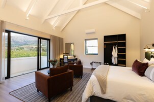 Un dormitorio moderno con una cama grande, un escritorio y vistas al exterior.