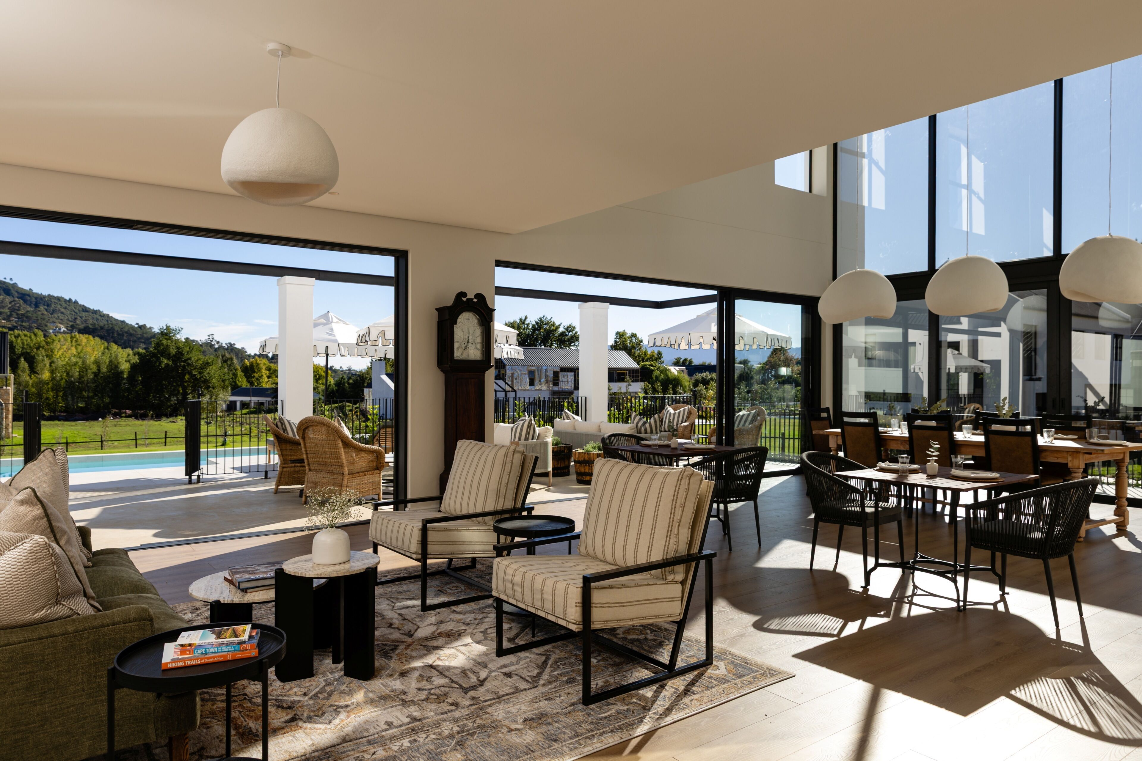 A spacious living area with a large window, a dining table, and comfortable seating.