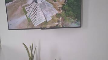 Een televisie aan een muur bevestigd, toont een overzicht van een historisch gebouw.
