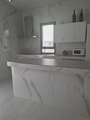 Cafetera o tetera, frigorífico, microondas y placa de cocina