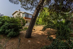 Il s’agit d’une propriété résidentielle dotée d’un jardin bien entretenu, d’un chemin en pierre et d’une maison avec un balcon apparent.