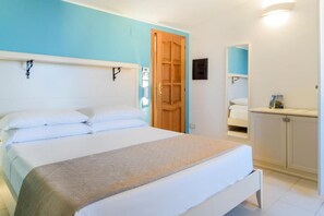 Ein Schlafzimmer mit einem Bett, einer Holztür, einem Nachttisch und einem fest eingebauten Regal.
