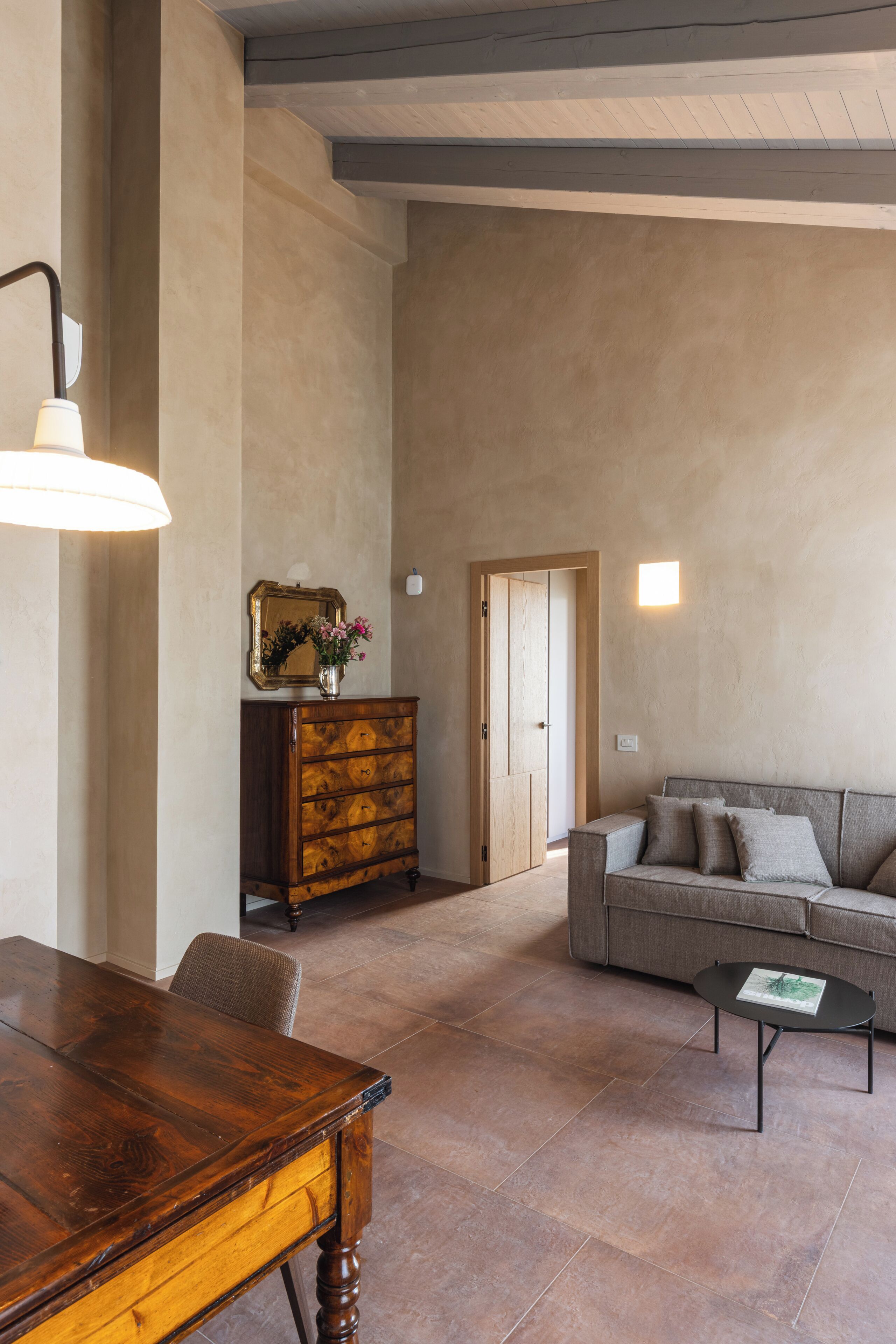 Un salón amplio con una mesa de comedor de madera, un sofá y una mesa baja.
