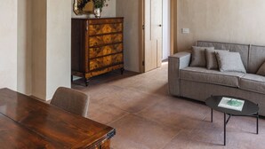 A spacious living area with a wooden dining table, a sofa, and a coffee table.