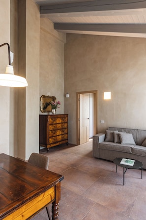 A spacious living area with a wooden dining table, a sofa, and a coffee table.
