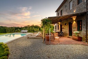 A poolside area with lounge chairs, a table, and a pergola. - Villa Pellegrini with breathtaking view (Montecarlo)