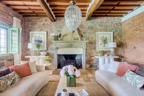 A cozy living room with a fireplace, two sofas, and a coffee table. - Villa Pellegrini with breathtaking view (Montecarlo)