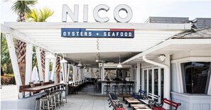 An outdoor dining area with a covered patio, tables, and chairs. - Lowcountry Lux, 5 min to Beach, 7 min to Dtwn (Mount Pleasant)