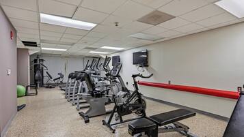 A gym with various exercise equipment, including treadmills, stationary bikes, and weight machines.