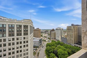 A cityscape with high-rise buildings, a clear sky, and a road with vehicles.