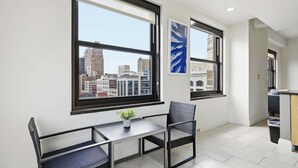 A modern room with a city view, a dining table, and a chair.