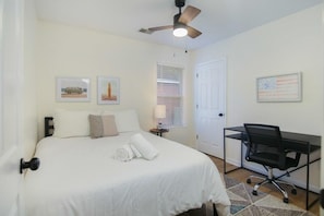 A bedroom with a bed, a desk, and a ceiling fan. - Charleston Oasis With Hot Tub, Mins to Dtwn (Mount Pleasant)