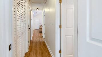 A hallway with white doors and a wooden floor.