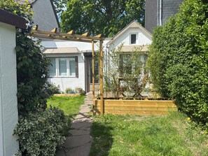 A residential property with a covered patio, a wooden fence, and a well-maintained garden. - 3-Star Vacation Rental “La maison de Doris” (Bihorel)
