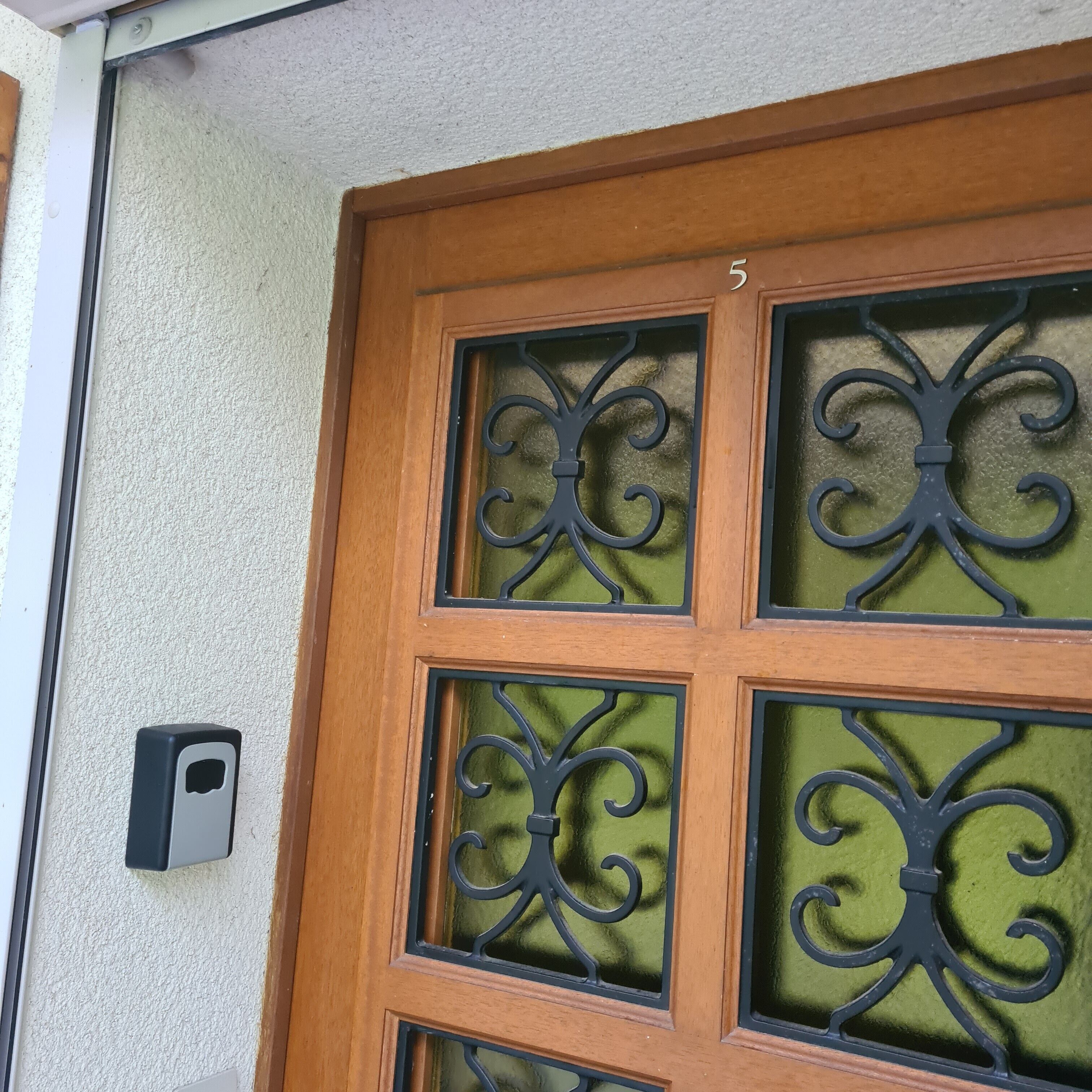 Uma porta de madeira com painel de vidro e dispositivo de segurança.