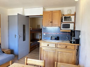 A compact kitchen with wooden cabinets, a microwave, a toaster, and a coffee maker. - Cabin studio with mountain view (Les Deux Alpes)