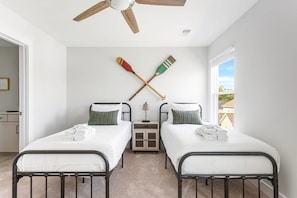 A bedroom with two beds, a ceiling fan, and a window with a view. - The Trendy In Park Circle Mins to DT CHS & Beach (North Charleston)