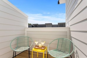 A small outdoor patio with two wicker chairs and a yellow table, featuring a pitcher and glasses. - The Trendy In Park Circle Mins to DT CHS & Beach (North Charleston)