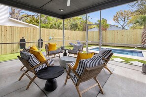 A covered patio with outdoor furniture, a pool, and a view of the backyard. - Music Manor-3-king Beds-pool-mins To Beach & DT (Mount Pleasant)