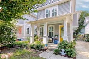 A two-story house with a covered porch, a front yard with various plants, and a visible door. - Holy City Charm-mins To Dtwn-beach & Shem Creek (Mount Pleasant)