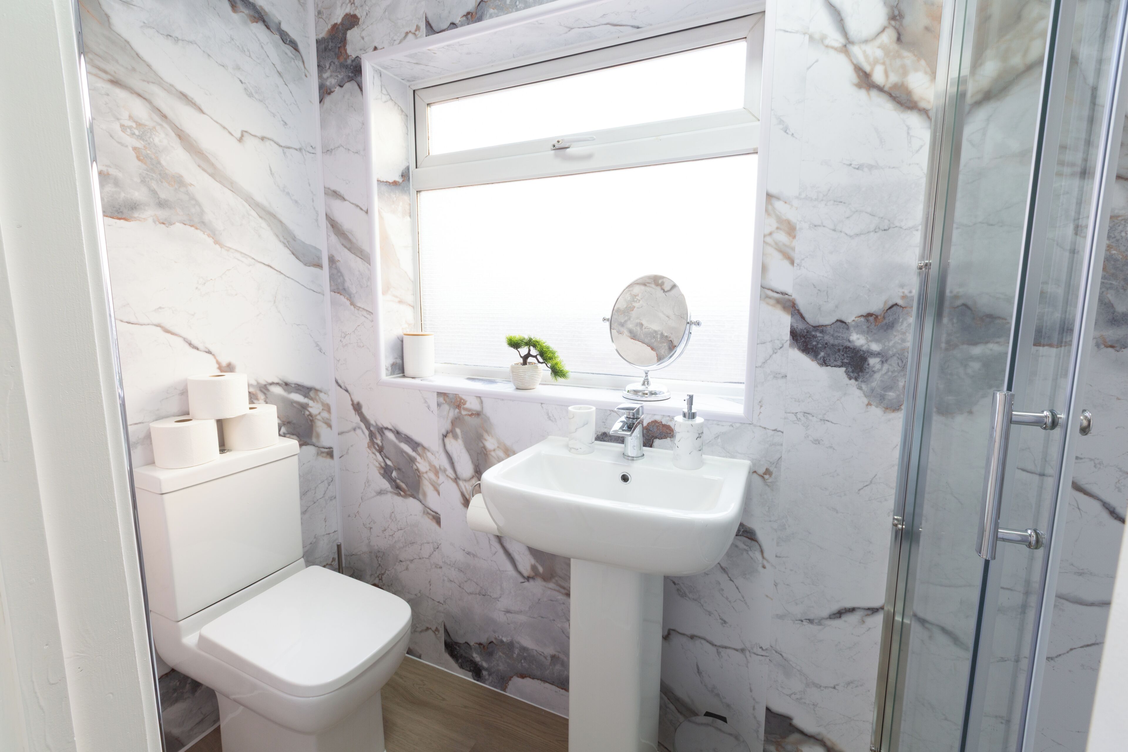 A bathroom with a toilet, sink, and shower.