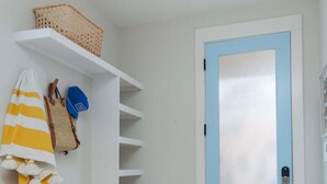 A hallway with a blue door, white shelves, and a basket on the top shelf. - Happy Ours, Mins to Park Circle, Dtwn, CHS Beach (North Charleston)