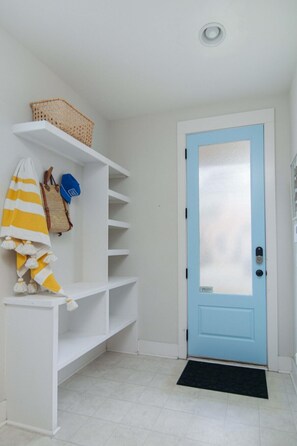 A hallway with a blue door, white shelves, and a basket on the top shelf. - Happy Ours, Mins to Park Circle, Dtwn, CHS Beach (North Charleston)