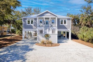 A two-story house with a balcony, a front porch, and a driveway. - Jungle House-heated Pool-pet Friendly-luxury (Edisto Island)