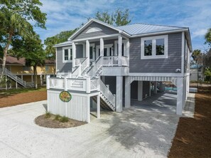 A two-story house with a covered porch and a small deck. - Jungle House-heated Pool-pet Friendly-luxury (Edisto Island)