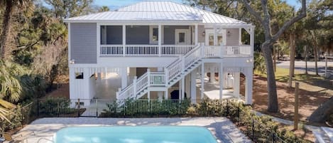 A two-story house with a balcony, a pool, and a staircase leading to the upper level.