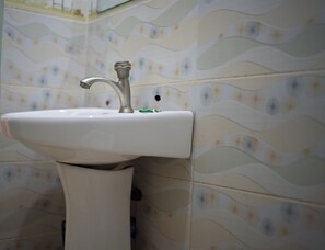 Un lavamanos de baño con un lavabo de cerámica blanca y un grifo plateado.