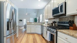 A modern kitchen with stainless steel appliances, granite countertops, and white cabinetry. - The Jade, Park Circle, Mins to Dwtn and Beaches (North Charleston)