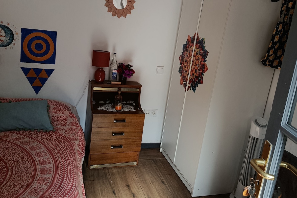 Un dormitorio con cama, cómoda, armario y decoración de pared.