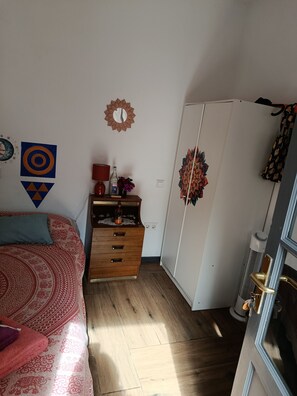 Un dormitorio con cama, cómoda, armario y decoración de pared.