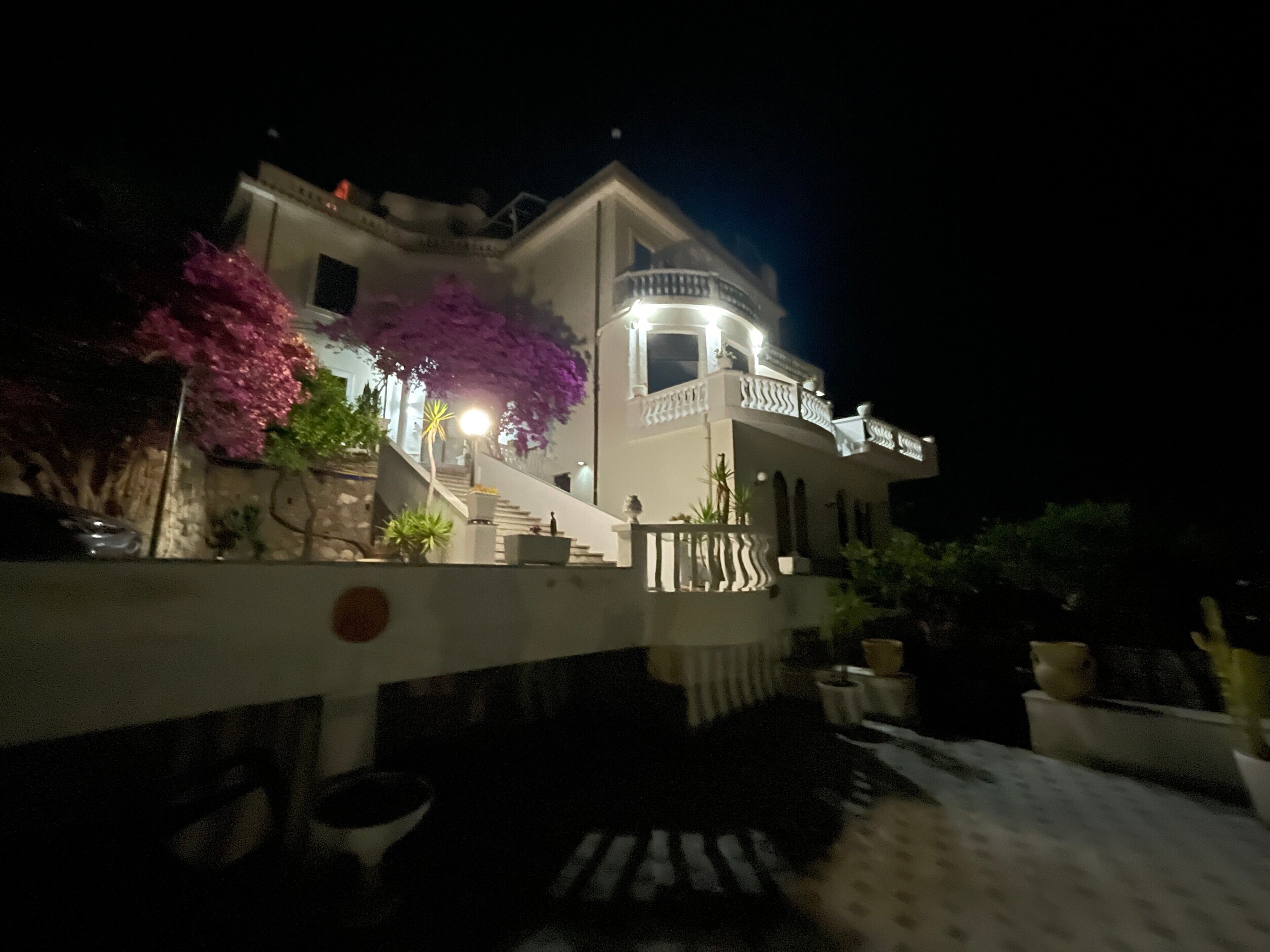 A two-story building with a balcony and a staircase leading to the upper floor.